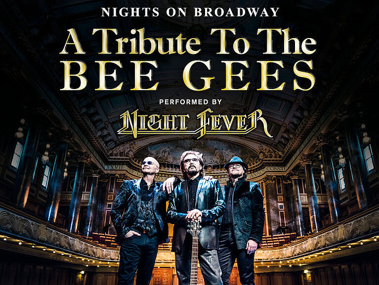 Das Trio Night Fever steht auf einer Bühne in einem Konzertsaal und die Show "Nights on Broadway - A Tribute to the Bee Gees" wird angekündigt.